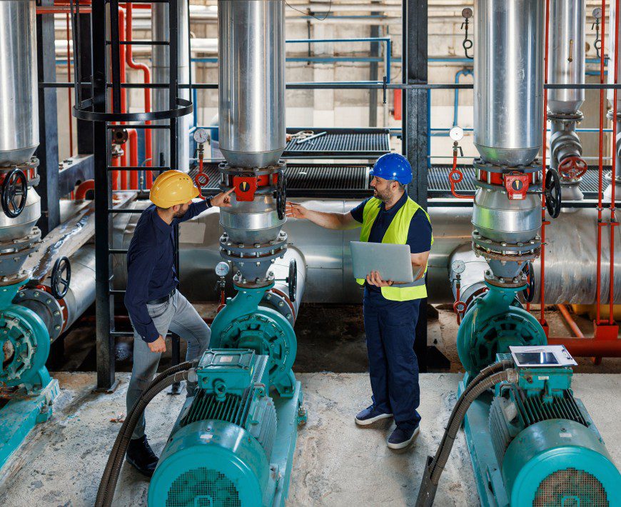 Engineers inspecting industrial machinery in a plant.