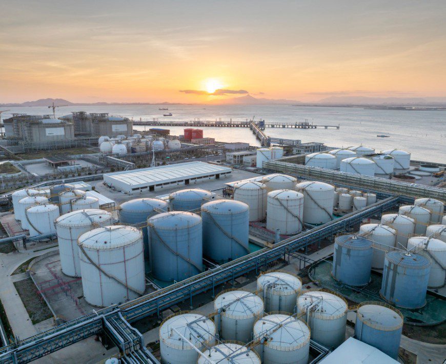 Oil refinery tanks with sunset background