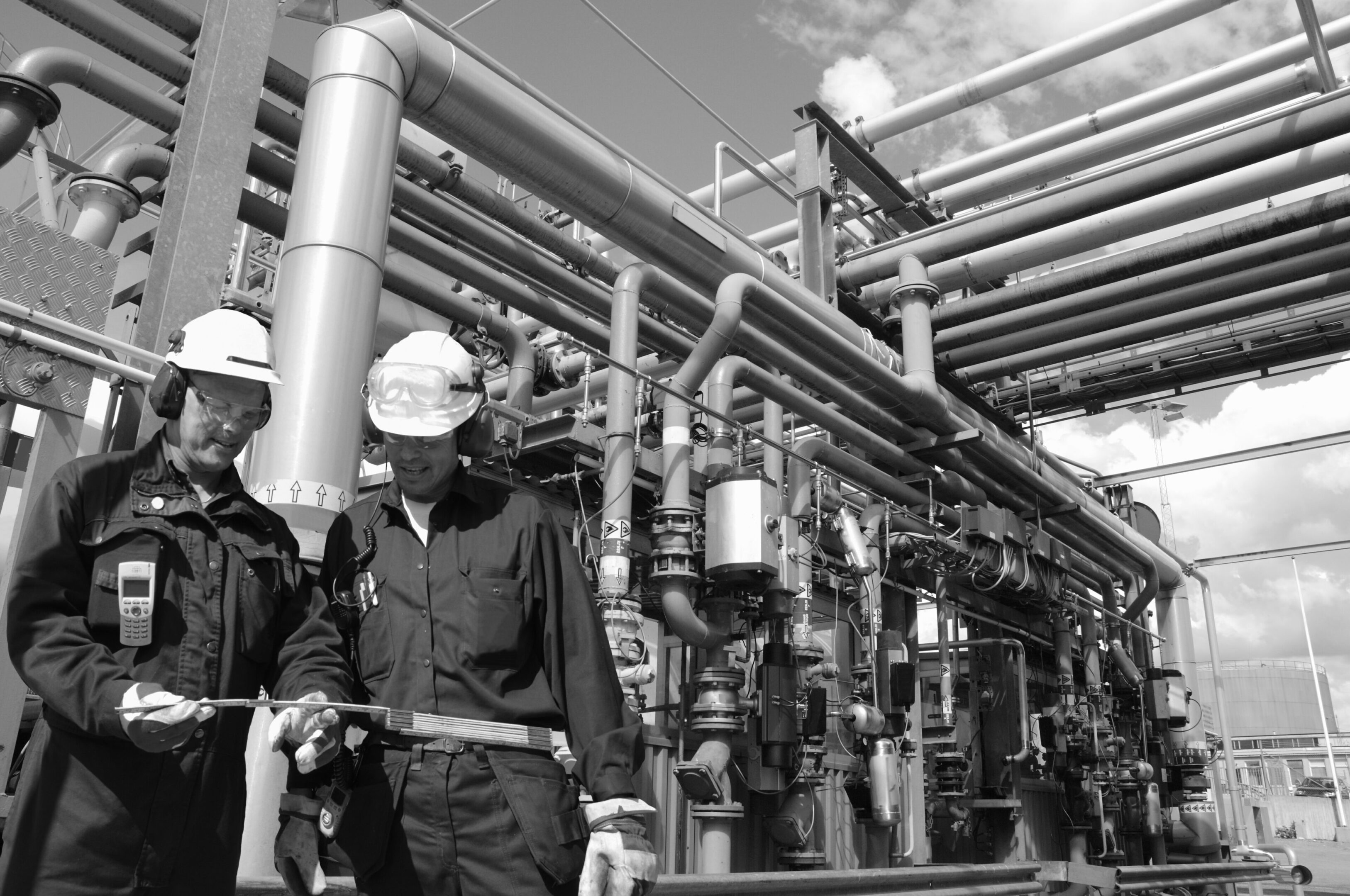 Two industry workers inside oil and gas installation, pipeline main fuel depot